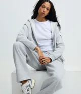 Saco negro de algodón con felpa, con capucha ajustable mediante cordón, mangas largas, cierre delantero de cremallera y bolsillos funcionales.