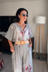 Pantalón palazzo verde claro con estampado de flores rosas, cintura elástica y lazo ajustable.