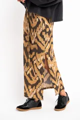 Falda midi de viscosa con estampado abstracto en tonos marrón, beige y negro. Tiene cintura elastizada con cordón ajustable y abertura lateral.