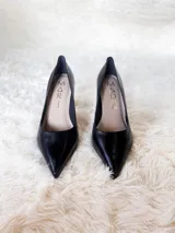 Zapato de tacón alto Iara, color negro charol, con punta fina y suela roja. Fabricado en cuero.