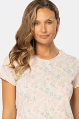 Remera blanca estampada con flores azules y beige, de manga corta y cuello redondo.