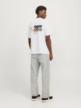 Camiseta blanca de manga corta y cuello redondo con estampado pequeño en el pecho.