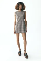 Vestido corto de Zara Woman Collection con estampado a cuadros en tonos grises, cuello redondo y sin mangas. Cierre trasero con cremallera oculta.