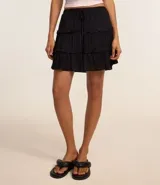 Minifalda negra texturizada de viscosa con cintura elástica, lazo ajustable y volados.