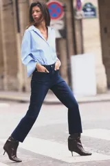 Jeans de tiro alto con bolsillos de plastrón en delantero y espalda, corte mini flare y largo cropped. Cierre frontal con cremallera y botón metálico.