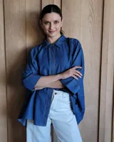 Camisa oversize de denim azul oscuro, con cuello camisero, cierre frontal con botones y mangas 3/4.