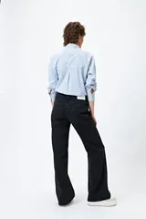 Pantalón de jean negro de corte recto, tiro medio y calce relajado. Presenta un recorte lateral en tono contrastante.