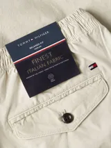Bermuda color beige de algodón y elastano, con cintura elástica ajustable con cordón, cuatro bolsillos y logo de Tommy Hilfiger bordado en el bolsillo trasero.