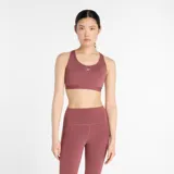 Top deportivo New Balance Essential Run Bra color borgoña, de soporte completo, diseñado para actividades de alto impacto. Confeccionado con tejido de secado rápido NB DRY, relleno incorporado, banda inferior ajustable con cierre de gancho y ojal, y tirantes regulables.