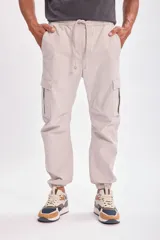 Pantalón cargo jogger gris claro con bolsillos laterales y tobillos ajustados.