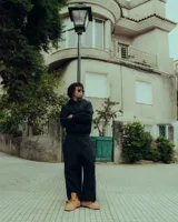 Conjunto deportivo negro, compuesto por un buzo con capucha y bolsillo canguro, y un pantalón de jogging. Ambas prendas tienen estampado puff en el pecho/muslo con el logo de la marca.