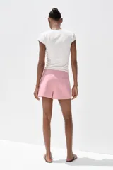 Falda pantalón corta color rosado, de tiro medio con abertura en el delantero y cierre lateral con cremallera.