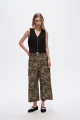 Pantalón capri negro con estampado floral en color crema, de corte ancho y tiro alto.