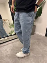 Pantalón de jean celeste claro, corte baggy, con roturas y desgaste.