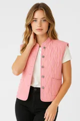 Chaleco rosa acolchado con cuello mao, cierre frontal con botones metálicos y bolsillos delanteros.