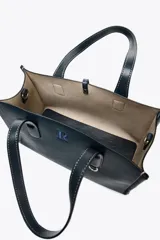 Bolso shopper azul marino de mano con doble asa y pespuntes a contratono. Incluye bolsa de tela extraíble con cierre fruncido y correa extraíble de tejido para usar como bandolera.