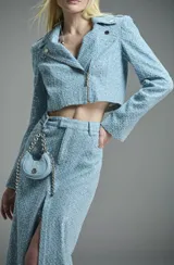 Chaqueta de jean azul con bordado de lentejuelas, diseño cropped y detalle de cierre frontal.