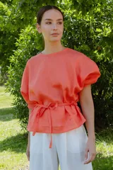 Blusa color verde lima, de manga tres cuartos con leve volumen y largo hasta la cadera. Incluye cinto extraíble en espalda que permite anudar para modificar la silueta.