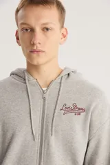 Buzo canguro con capucha y cierre frontal de la marca Levi's, color gris con logo bordado en el pecho. Tiene bolsillos laterales y puños y cintura acanalados.