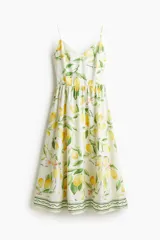 Vestido midi de algodón con estampado de limones, breteles finos ajustables, escote en V y espalda fruncida. Tiene corte en la cintura y falda acampanada.