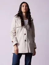 Gabardina impermeable color beige, marca Weatherproof, con abertura central con botones, bolsillos delanteros y capucha desmontable.