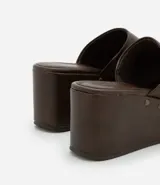 Sandalia marrón de cuero sintético con plataforma y remaches plateados.