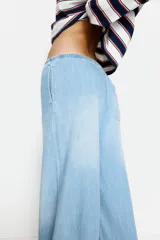 Pantalón denim celeste de corte ancho, con cintura elastizada y cordón ajustable.