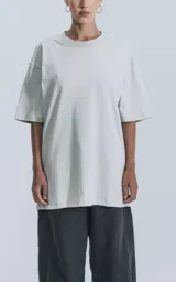 Remera gris de corte crop y calce oversize, con hombros caídos y cuello redondo.
