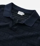 Remera polo de hombre color beige, con cuello en V, mangas cortas y textura patchwork calada.