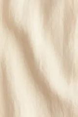 Vestido corto sin mangas color beige. Modelo levemente evasé con escote redondo, abertura de cerradura con botón oculto en la nuca y bajo recto. Parcialmente forrado.