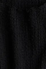 Vestido corto negro entallado de punto con textura arrugada y escote barco.