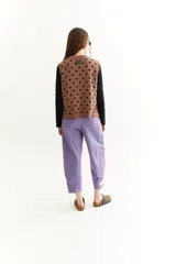 Chaleco tejido en jacquard negro con lunares azules, de corte cuadrado y sisas amplias.