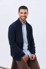 Campera tejida de lana color azul marino, con cuello alto, cierre metálico frontal y bolsillos laterales. Presenta detalles en cuero y logo bordado.