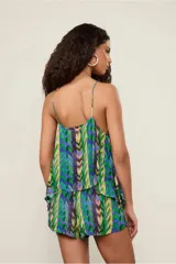 Top de tirantes con estampado geométrico en tonos verdes, azules y amarillos. Presenta escote recto y bajo asimétrico.