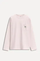 Camiseta de manga larga color rosa claro, con cuello redondo y bolsillo de parche en el pecho con logo bordado.