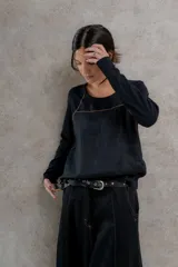 Remera negra de manga larga con costuras decorativas en color ocre en hombros y escote.