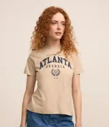 Remera color beige de algodón, de corte recto, con cuello redondo y mangas cortas. Estampa frontal con la palabra "Atlanta" en azul marino, el texto "Georgia" y un diseño de corona de laureles.