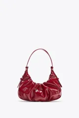 Bolso de hombro rojo con efecto craquelado y detalle fruncido. Tiene asa corta con detalles metálicos, bolsillo interior con cierre y cierre imantado.