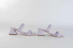 Sandalias de tacón fucsia con dos tiras con tachas piramidales y tacón cuadrado.