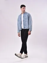 Campera de jean celeste con cuello clásico, cierre frontal con botones metálicos, bolsillos con solapa en el pecho y bolsillos laterales.