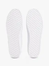 Zapatillas de corte bajo confeccionadas en piel napa color blanco. Presentan una franja lateral de tejido trenzado con los colores distintivos de la marca y una insignia metálica con el monograma TH. Cuentan con cordones al tono, suela de goma vulcanizada y logo en relieve en el talón.