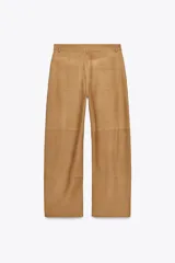 Pantalón de cuero color camel, de tiro alto, corte recto y bolsillos delanteros y traseros.