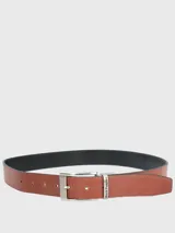 Cinturón de cuero negro con interior marrón, hebilla metálica plateada con el logo de Hush Puppies grabado.