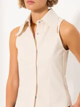 Camisa sin mangas confeccionada en tela de punto lisa, color negro, de corte regular. Lleva cartera con broches JCH y pinzas que entallan la prenda.