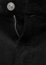 Pantalón de pana negro de corte wide leg, tiro medio, cinco bolsillos y cierre de cremallera y botón.