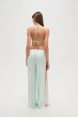 Pantalón largo de tela fluida con estampado de cebra en tonos rosa y fucsia. Tiene corte ancho y aberturas laterales con detalle de argollas.