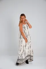 Vestido largo de tirantes color crudo con estampado de arabescos en negro, corte suelto y elástico en la parte superior.