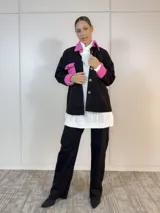Sobre camisa negra con canesú, bolsillo y puños en color fucsia.