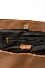 Bolso tipo shopper color negro con apliques de tachas plateadas en los bordes y las asas.
