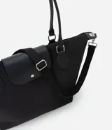 Cartera grande negra de poliéster con cierre de cremallera y solapa. Tiene doble asa, una fija para el hombro y otra transversal desmontable.